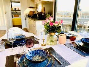 une table avec des assiettes et des verres bleus et un vase de fleurs dans l'établissement Hausboot inkl Motorboot, Ostsee, à Heiligenhafen