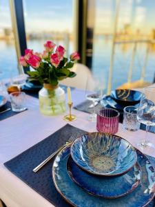 a table with blue plates and a vase of flowers at Hausboot inkl Motorboot, Ostsee in Heiligenhafen