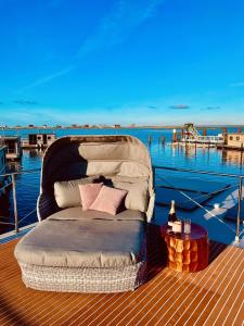 un lit assis sur le pont d'un bateau dans l'établissement Hausboot inkl Motorboot, Ostsee, à Heiligenhafen