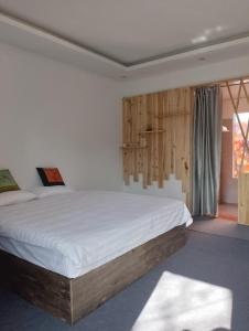 1 dormitorio con 1 cama grande con sábanas blancas en Tay Bac Sky Homestay, en Sa Pa