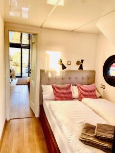 1 dormitorio con 2 camas y almohadas rojas y blancas en Hausboot inkl Motorboot, Ostsee, en Heiligenhafen