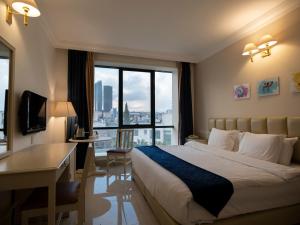 um quarto de hotel com uma cama e uma grande janela em Amman West Hotel em Amã
