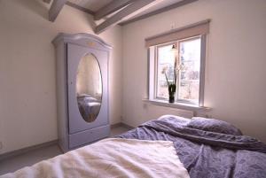 1 dormitorio con cama, espejo y ventana en Luxury cosy cottage by the sea en Karlstad