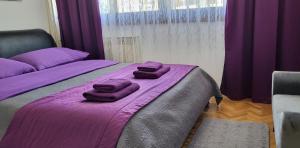 - une chambre avec 2 lits et des couvertures pourpres dans l'établissement APARTMENT AMBER s podzemnom garažom, à Split