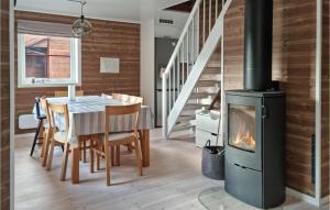 a fireplace in a dining room with a table and a stove at 3 Bedroom Cozy Home In Vikes in Vikeså