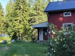 una casa rossa in mezzo a un cortile di Hideaway for holiday season, House with two saunas a Hämeenlinna
