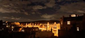 a city lit up at night with buildings at Studio Bohaterów Monte Cassino in Sopot