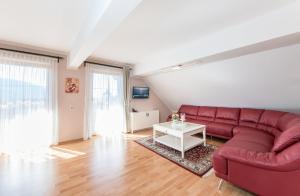 sala de estar con sofá rojo y mesa en Appartements Allmaier en Pörtschach am Wörthersee