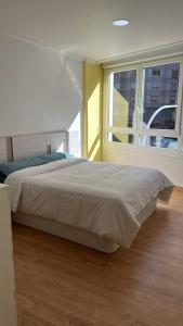 um quarto com uma cama grande e uma janela grande em Alojamiento Pichi em Vigo
