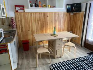 a small kitchen with a table and two stools at Charmant appartement au pied des pistes de Lelex in Lélex