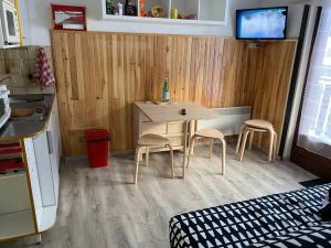 eine kleine Küche mit einem Tisch und 2 Stühlen in der Unterkunft Charmant appartement au pied des pistes de Lelex in Lélex