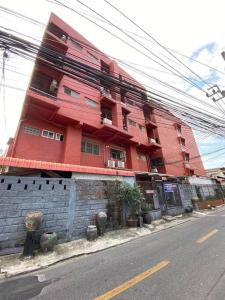 un bâtiment rouge sur le côté d'une rue dans l'établissement Ratanawong Place 304, à Bangkok