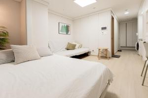 Un dormitorio blanco con una cama y un sofá. en Apartment THE SHARE Myeongdong, en Seúl 126 fotos más