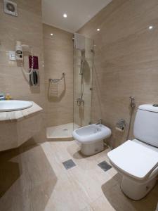 uma casa de banho com um WC, um lavatório e um chuveiro em Amman West Hotel em Amã