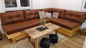 a brown couch in a living room with a table at Wood Apartmani - Vila Zimska idila Jahorina in Jahorina
