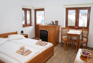Cet appartement comprend une chambre avec un lit et une cuisine avec une table. dans l'établissement Casa de oaspeti Kinga's Crown, à Băile Tuşnad