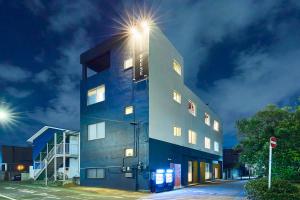 un edificio con una luz de la calle encima en Flower Base Lily House, en Fukuoka