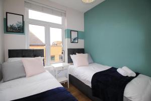 1 dormitorio con 2 camas y ventana en City Centre Gem in Southend near the beach, station and parking, en Southend-on-Sea