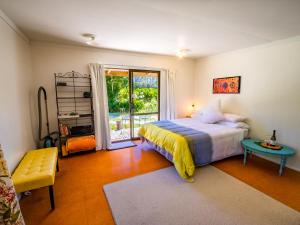 a bedroom with a bed and a table and a window at Bay Cottage - Takaka Holiday Unit in Takaka