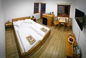 een slaapkamer met een groot wit bed en een tafel bij Casa de oaspeti Kinga's Crown in Băile Tuşnad