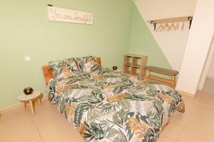 a bedroom with a bed with a colorful comforter at Cozy Nest By the Zoo in Mulhouse