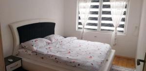 a bedroom with a white bed with flowers on it at Rooms-Vasva and Hazim in Ćukovi