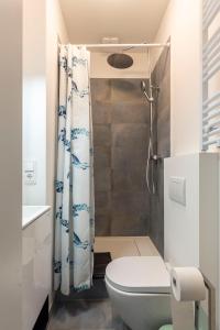 uma casa de banho com uma cortina de chuveiro e um WC em Central Apartment in Heart of Berlin em Berlim