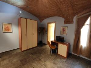 a room with a desk with a computer and a window at All'Imperatore in Cherasco
