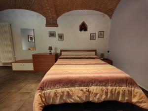 a bedroom with a bed and a dresser in it at All'Imperatore in Cherasco