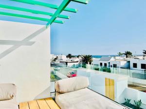 een balkon met een bank en uitzicht op de oceaan bij CIH Apartments in Puerto del Carmen