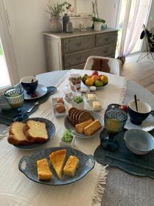 einen Tisch mit Brotplatten und Obst darauf in der Unterkunft Le Ch’ti Breizh home in Cléguer