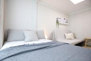 מיטה או מיטות בחדר ב-Apartment THE SHARE Myeongdong