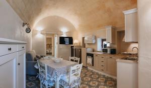 - une cuisine avec une table et des chaises dans la chambre dans l'établissement Casa Menodda, à Grottaglie