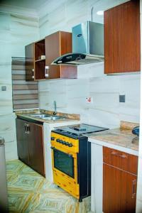 a kitchen with a yellow stove and a sink at Superb 2-Bedroom Duplex FAST WiFi+24Hrs Power in Lagos