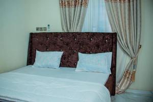 Bett mit einem Kopfteil aus Holz in einem Schlafzimmer in der Unterkunft Superb 2-Bedroom Duplex FAST WiFi+24Hrs Power in Lagos