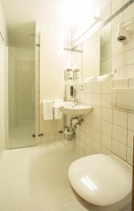 biała łazienka z umywalką i prysznicem w obiekcie Hotel an der Waldstraße w mieście Groß-Zimmern