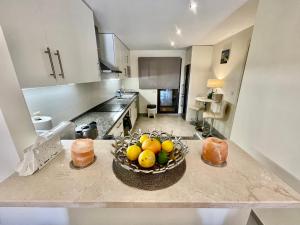 a kitchen with a bowl of fruit on a counter at Casares Beach Golf Apartment With Private Garden Direct Pool Access in Casares