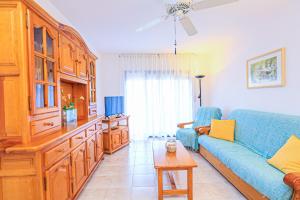 カンブリルスにあるRegata Litoral Costa Dorada - ONLY FAMILIESのリビングルーム(青いソファ、テーブル付)