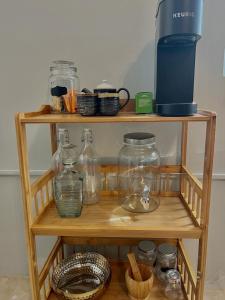 una estantería de madera con tarros de vidrio y otros artículos en ella en Runaway Bay The Vistas Townhome, en Runaway Bay