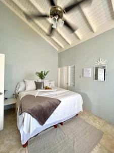 a bedroom with a large bed with a ceiling fan at Runaway Bay The Vistas Townhome in Runaway Bay