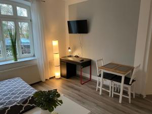 1 dormitorio con escritorio, mesa y escritorio en Möblierte Wohnung mit ruhiger Terrasse in bester Lage für Feriengäste und beruflich Reisende en Ottersberg