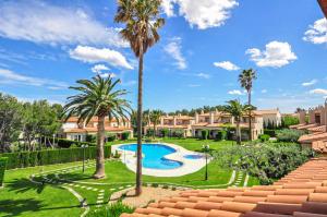 a resort with a swimming pool and palm trees at Las Brisas I - ONLY FAMILIES in Miami Platja