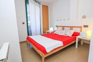 1 dormitorio con 1 cama con sábanas rojas y blancas en Ciutadella Litoral - ONLY FAMILIES, en Cambrils