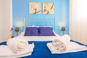 een blauwe slaapkamer met een bed met handdoeken erop bij Austral - ONLY FAMILIES in Cambrils