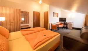 a hotel room with a bed and a couch and a table at Hotel an der Waldstraße in Groß-Zimmern