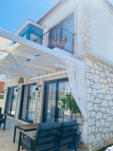 a house with two blue chairs and a balcony at Detached villa in Alaçatı… in Alaçatı