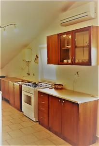 uma cozinha com armários de madeira e um forno com placa de fogão em Apartments Sakarun Soline em Soline