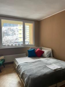 Un dormitorio con una cama con almohadas de colores. en Апартамент Родопско мече en Devin