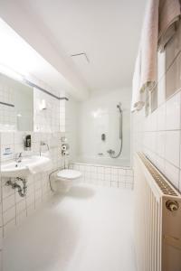 a white bathroom with a sink and a toilet at Hotel an der Waldstraße in Groß-Zimmern