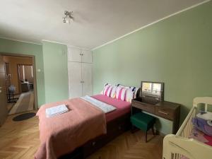 Schlafzimmer mit einem Bett und einem Schreibtisch mit einem Computer in der Unterkunft Апартамент Родопско мече in Dewin